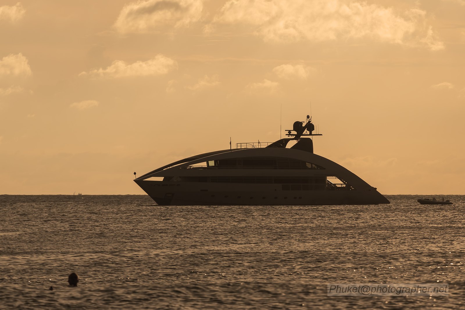 Premium motor yacht anchored on calm blue water at sunset