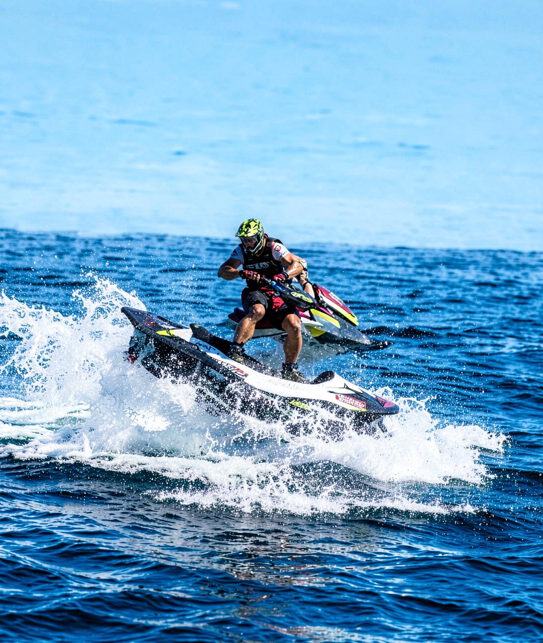 Jet ski rider mid-air over deep blue open water